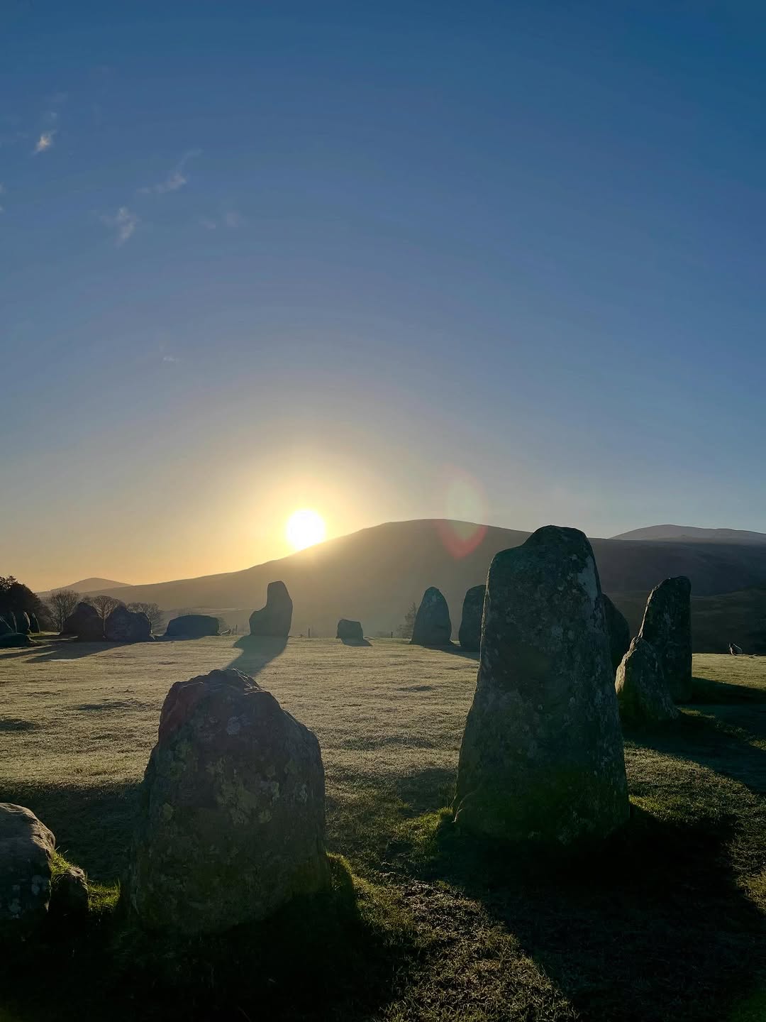 Stone circle at sunrise, echoing the spiritual tone of the work