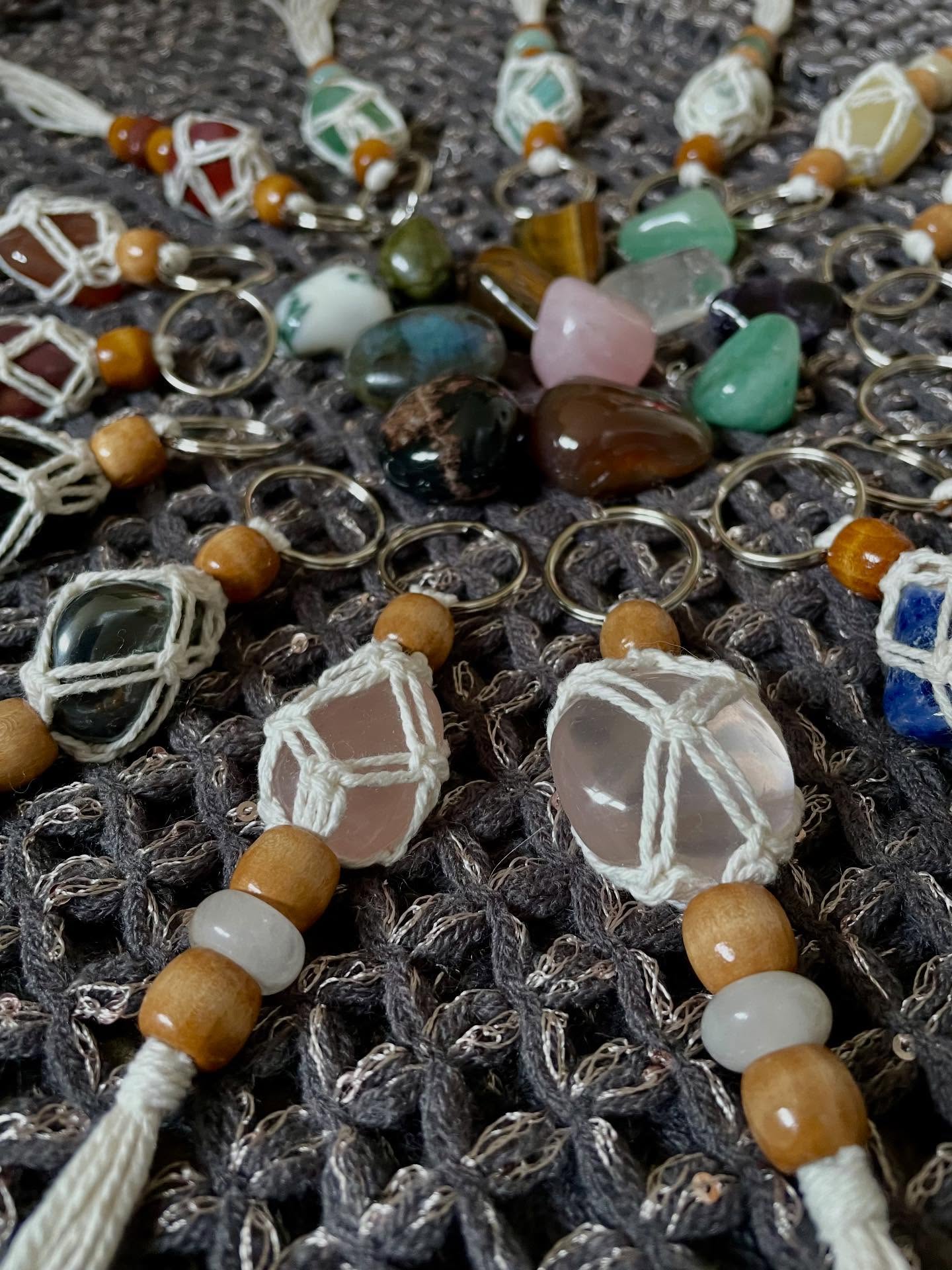 Close-up of crystal keyrings wrapped in white macrame with wooden beads