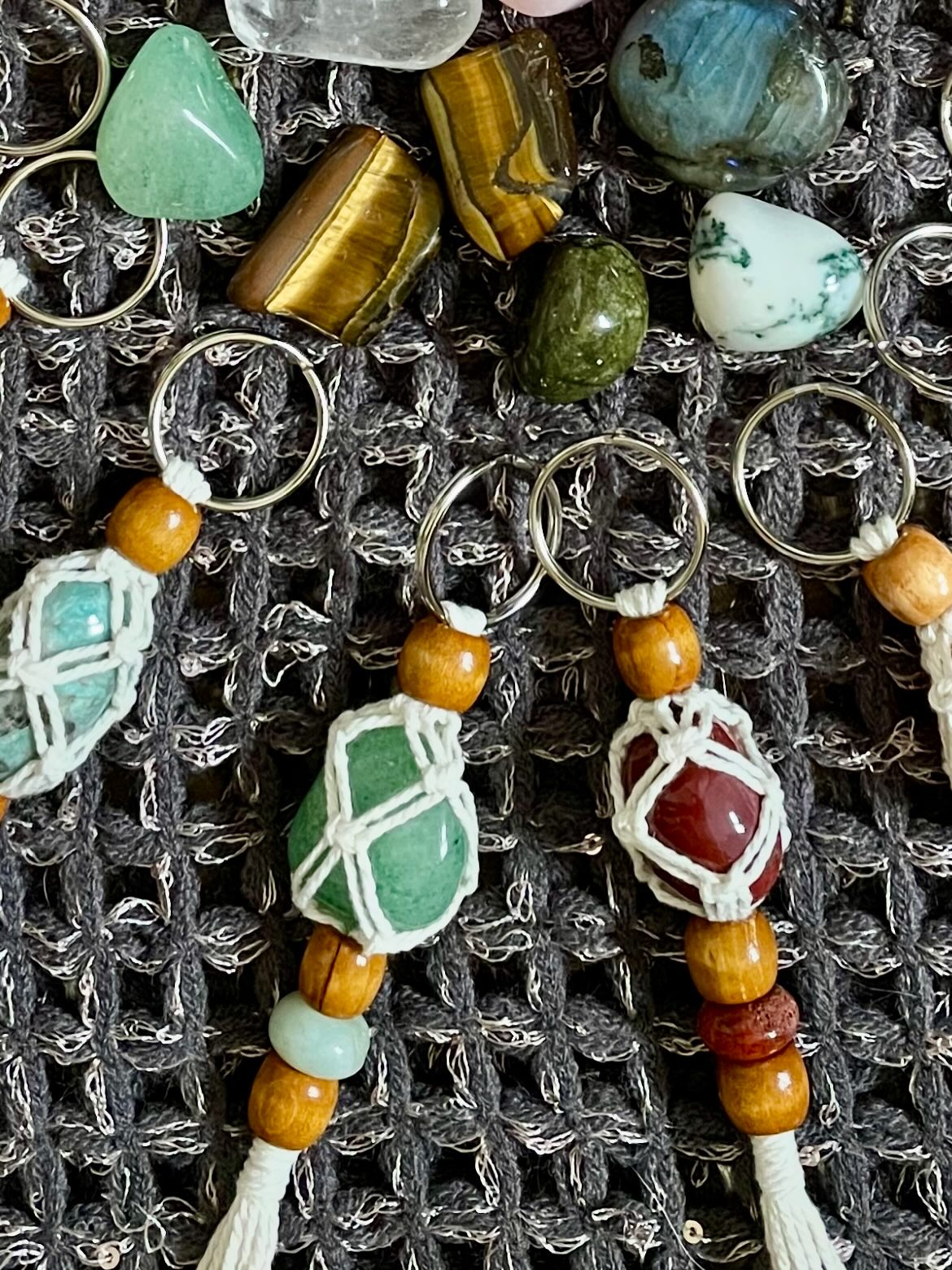 Close-up of stone keyrings wrapped in macrame knotwork