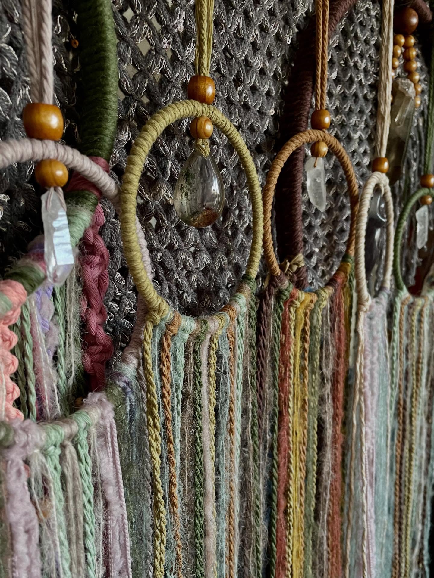 Close-up of circular macrame hangings with crystal drops at the market stall