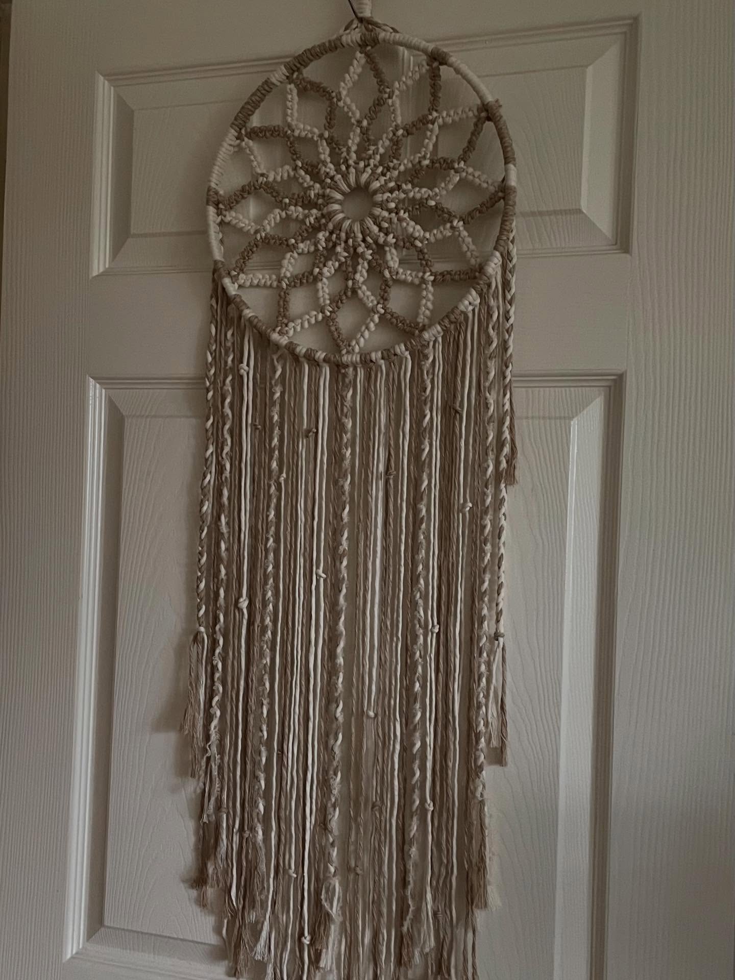 Neutral-toned macrame wall hanging with a circular woven centre